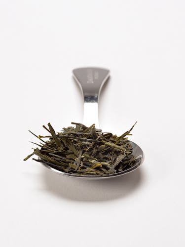 Cuillère à mesurer en acier inoxydable avec thé vert du Japon en vrac.