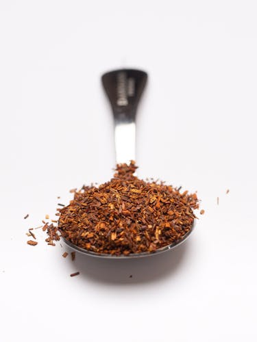 Cucchiaio dosatore in acciaio inossidabile con rooibos sfuso.