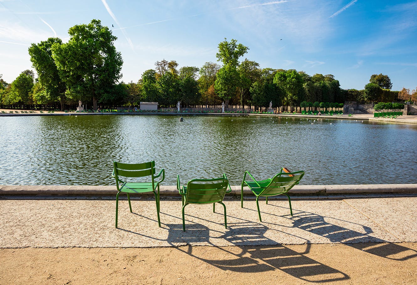 Sunny riverside in Paris with three chairs.