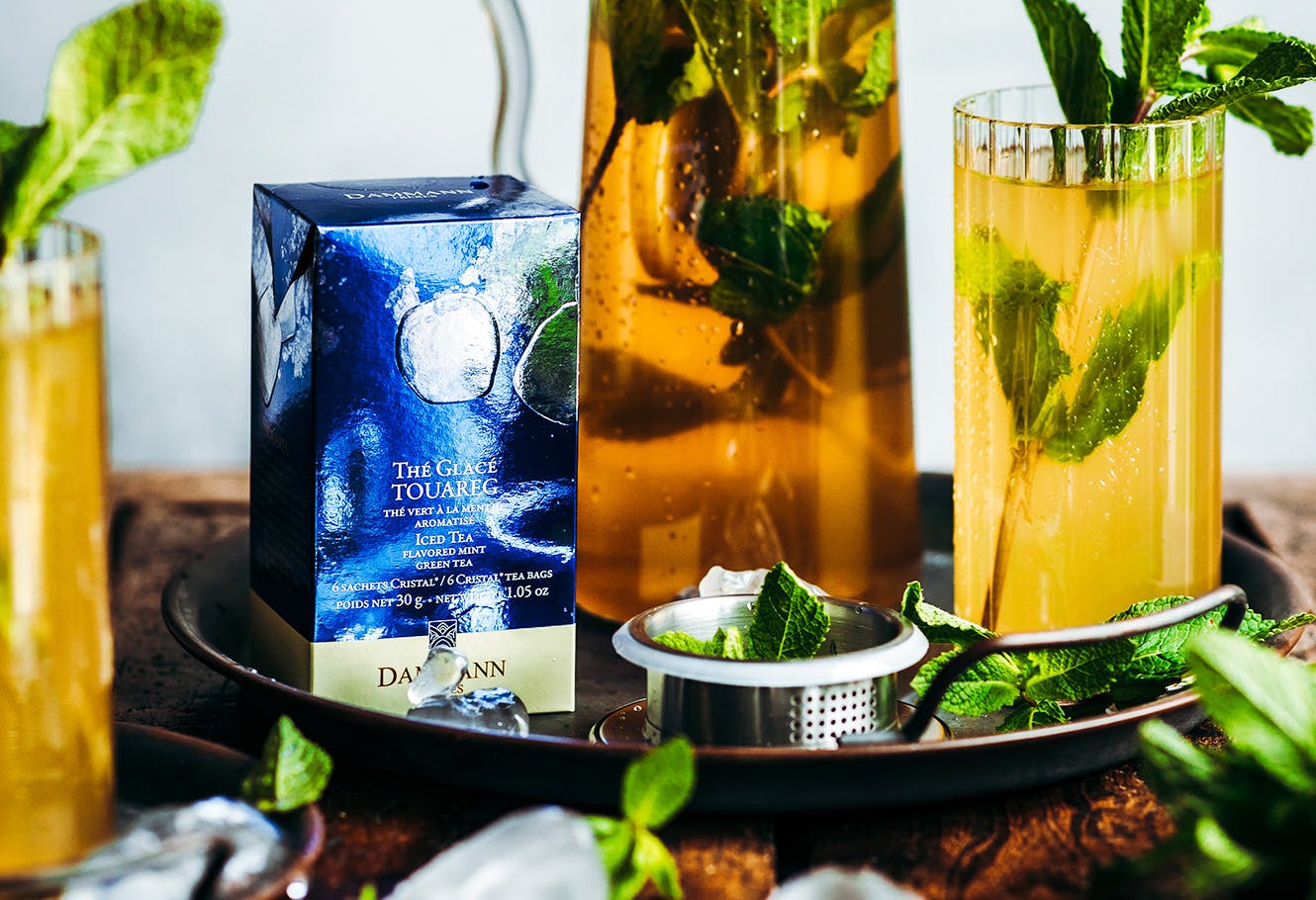Box of mint iced tea bags and glasses with fresh mint infusion.