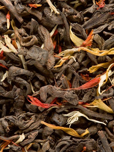 Té oscuro aromatizado a granel con pétalos de flores.