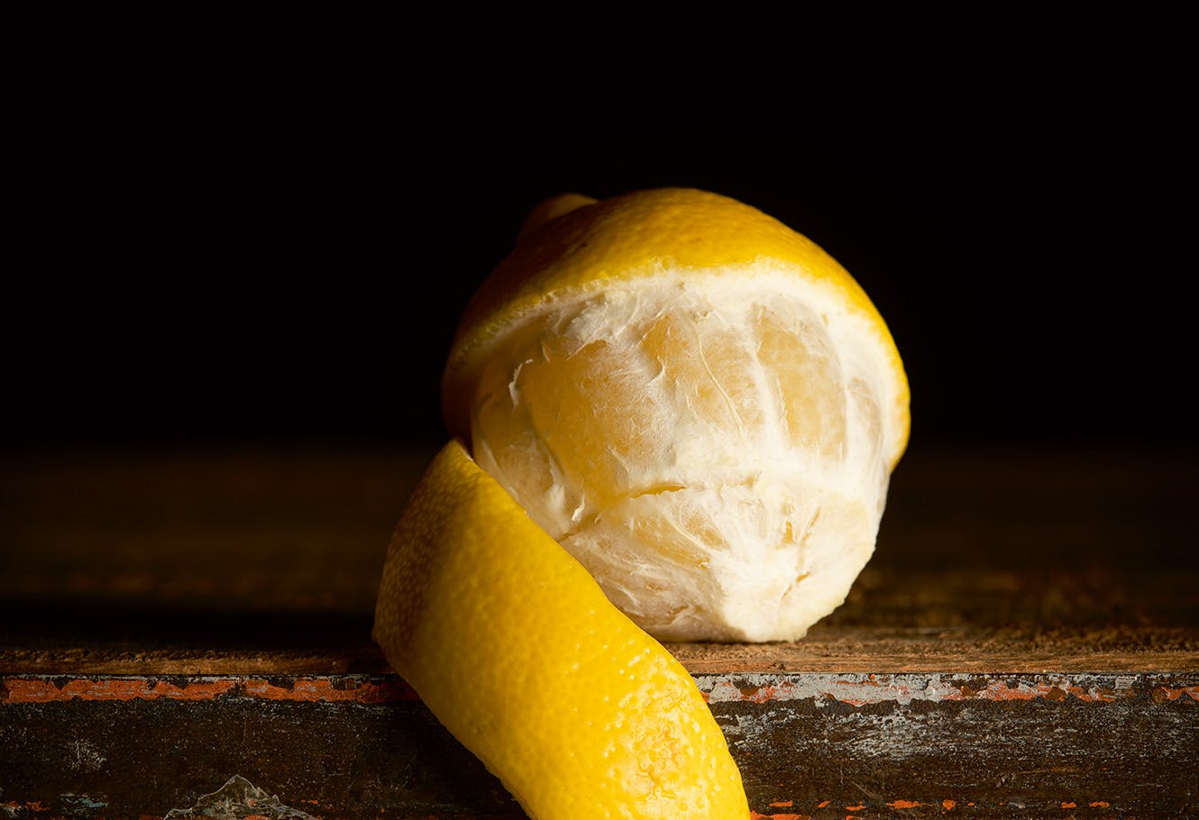 Fruit de bergamote jaune et son zeste sur une table.
