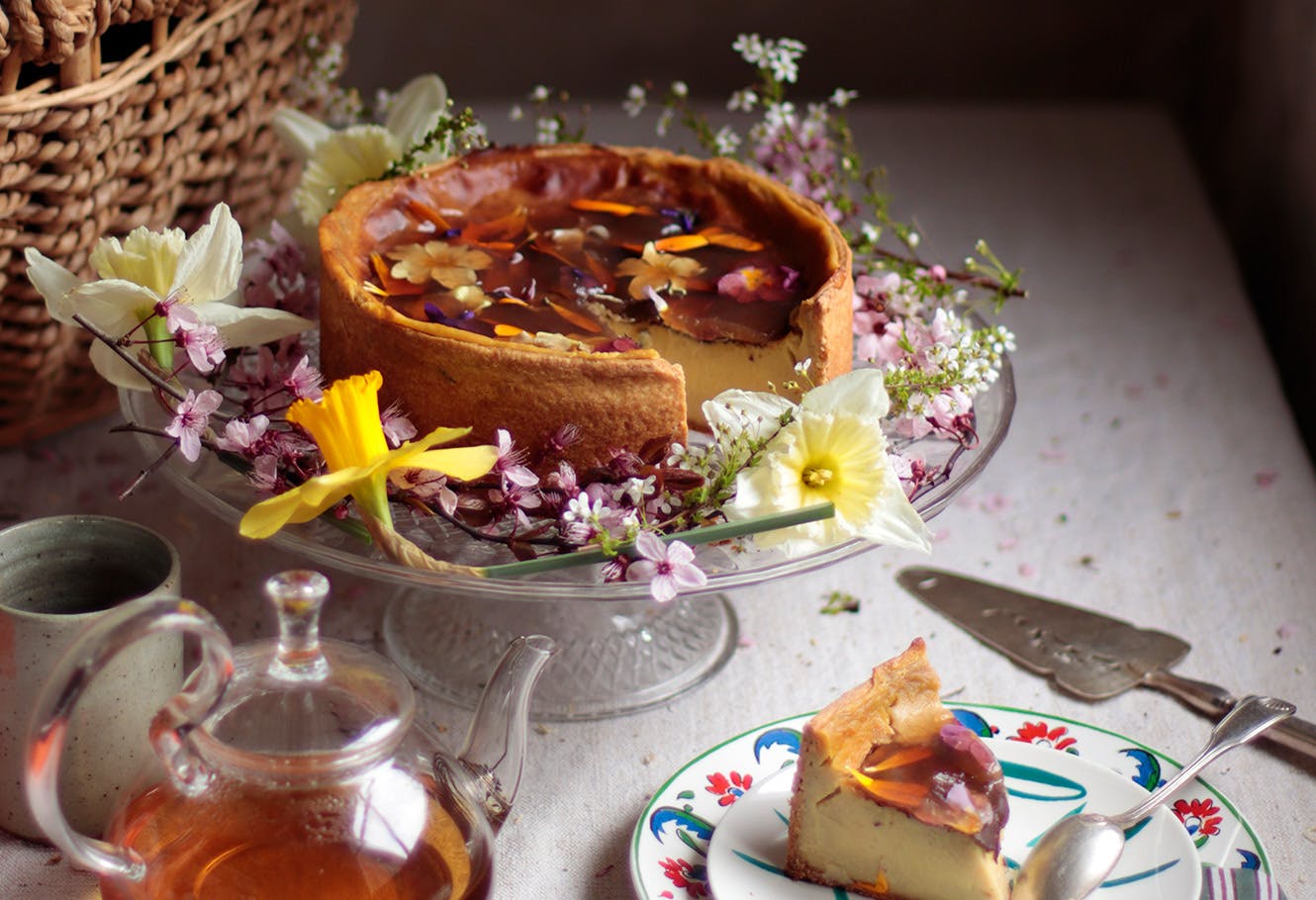 Pastry flan with white tea and flower jelly on a table.