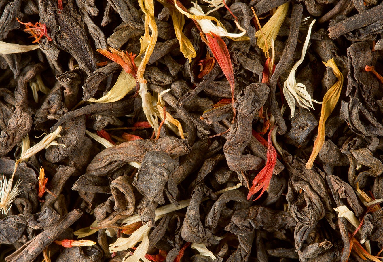Flavoured dark tea in bulk with flower petals.