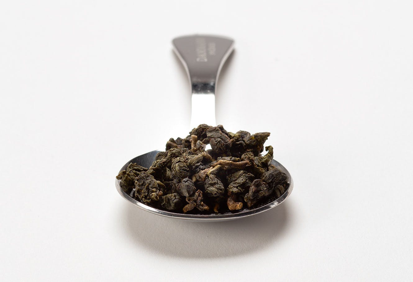 Cuillère à mesurer en acier inoxydable avec du thé oolong en vrac.