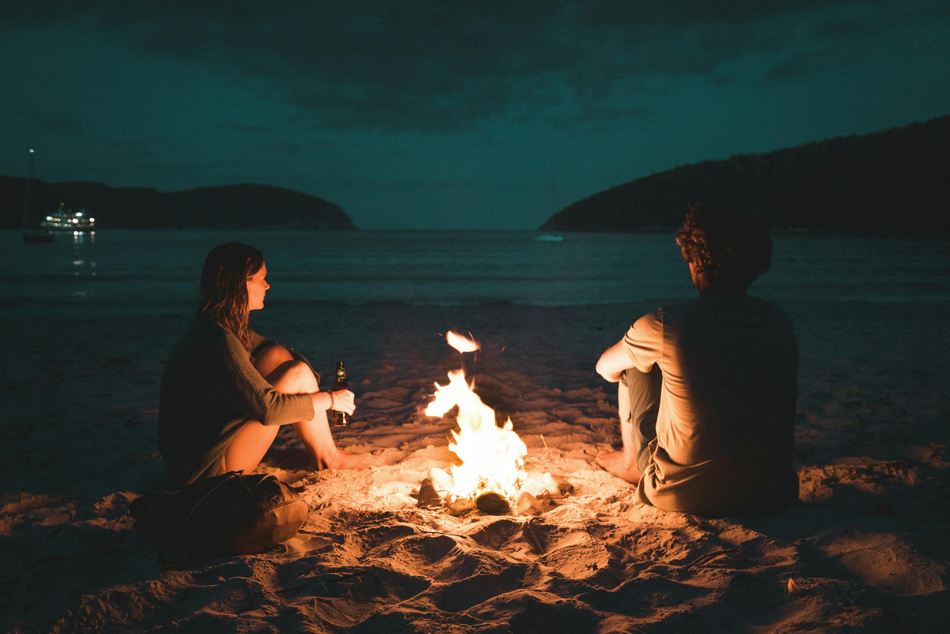 Paar am Lagerfeuer am Strand