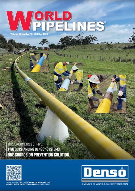Front cover of the October 2023 edition of World Pipelines Magazine. A pipeline running across a field with engineers working alongside.