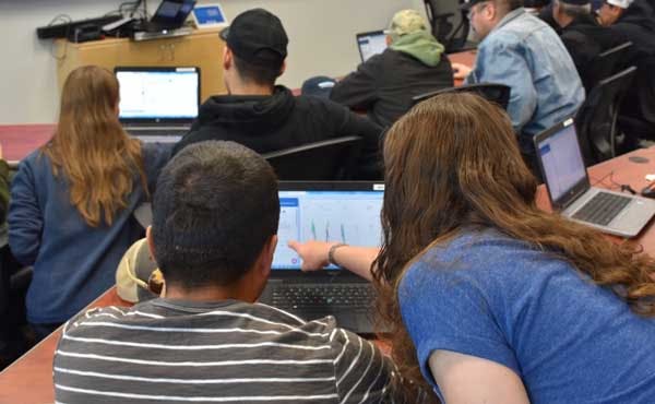 two people staring at a laptop as one points to the datastream visualization page being displayed