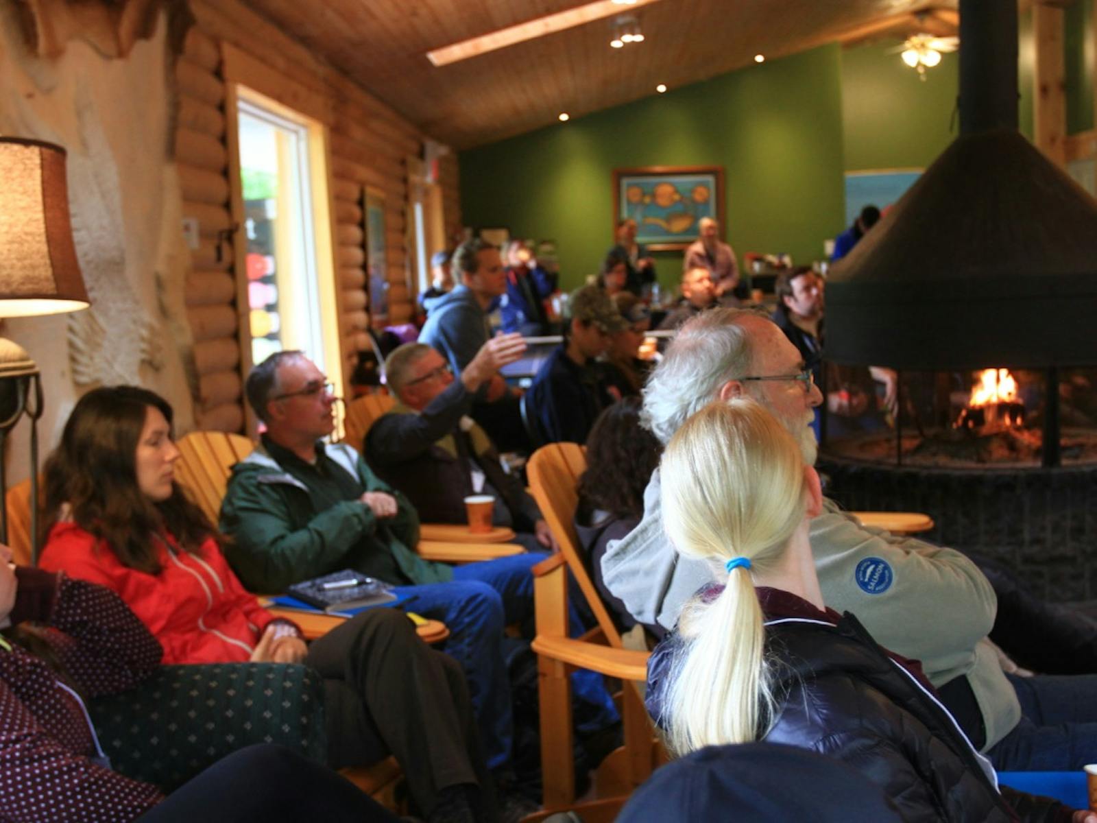 People sitting at a lodge by a fire at the atlantic datastream kickoff