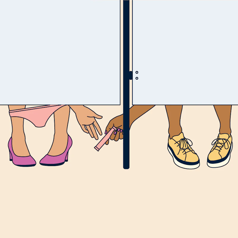 A person giving a tampon to a stranger in a public bathroom.
