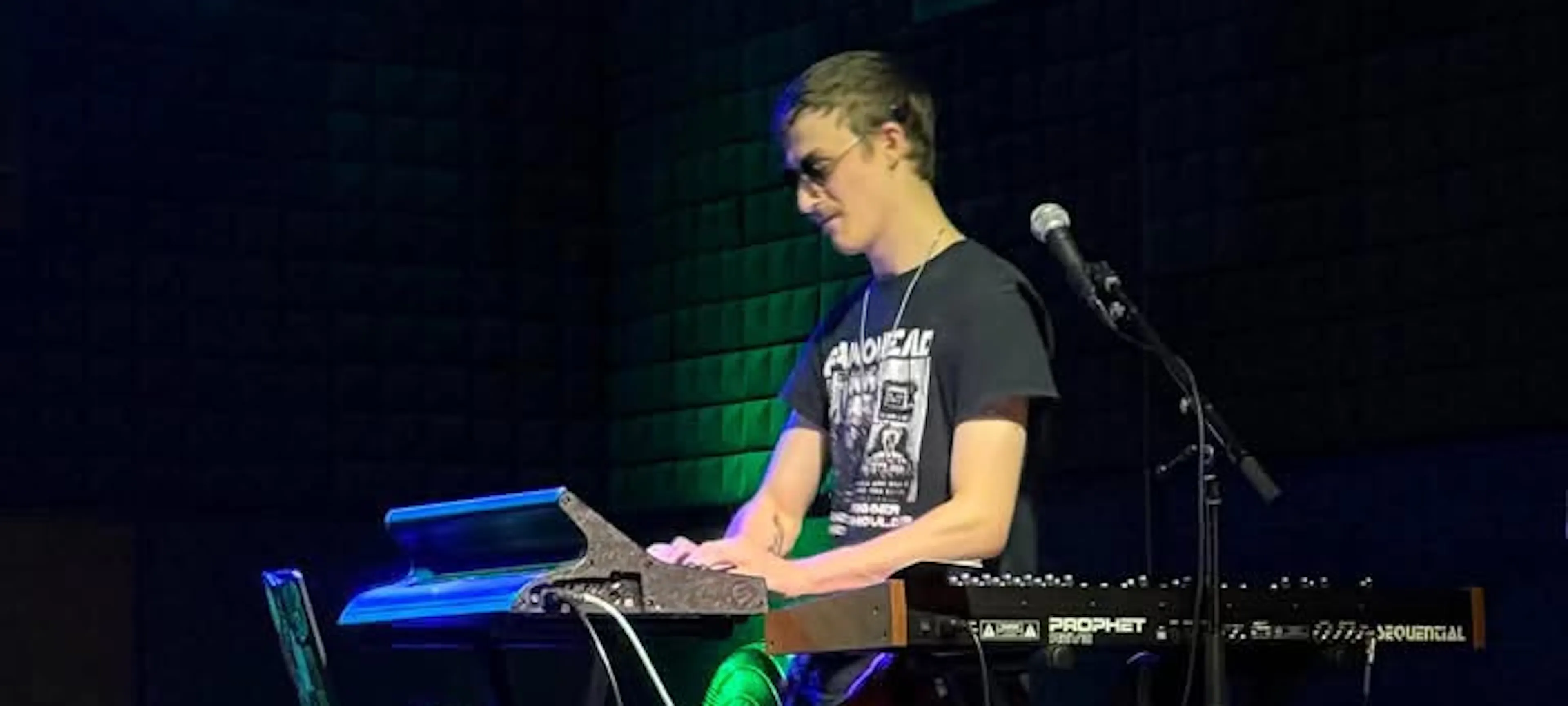 Luke playing the keyboard live. His cochlear implant is visible on the left side of his head.