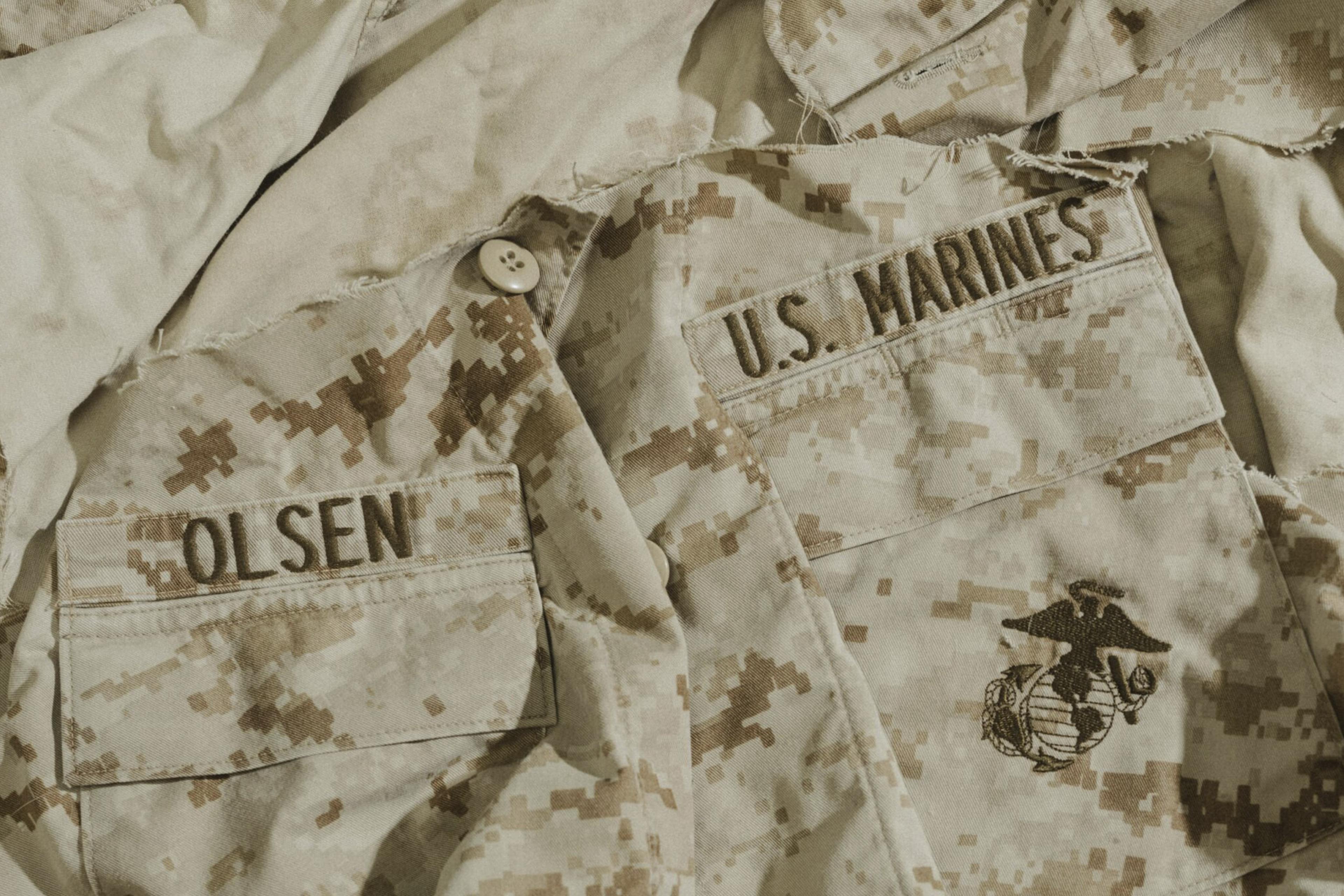 Background image showing a closeup of Scott Olsen's US Marines shirt.