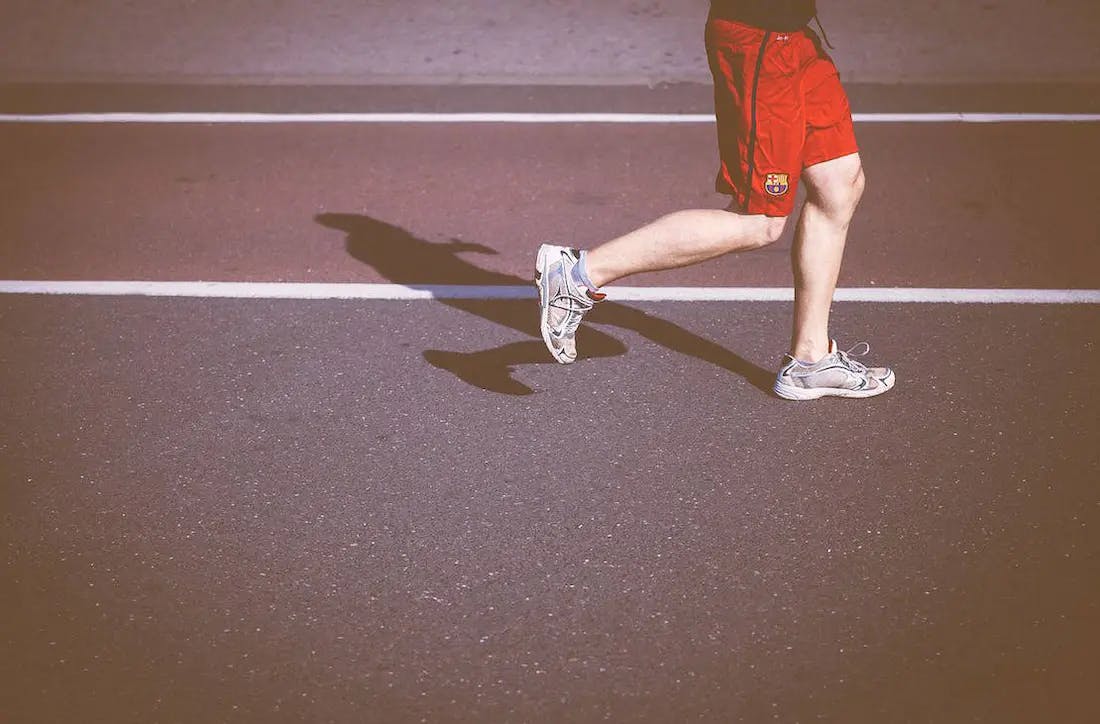 hombre caminando, detalle de las piernas y los zapatos deportivos