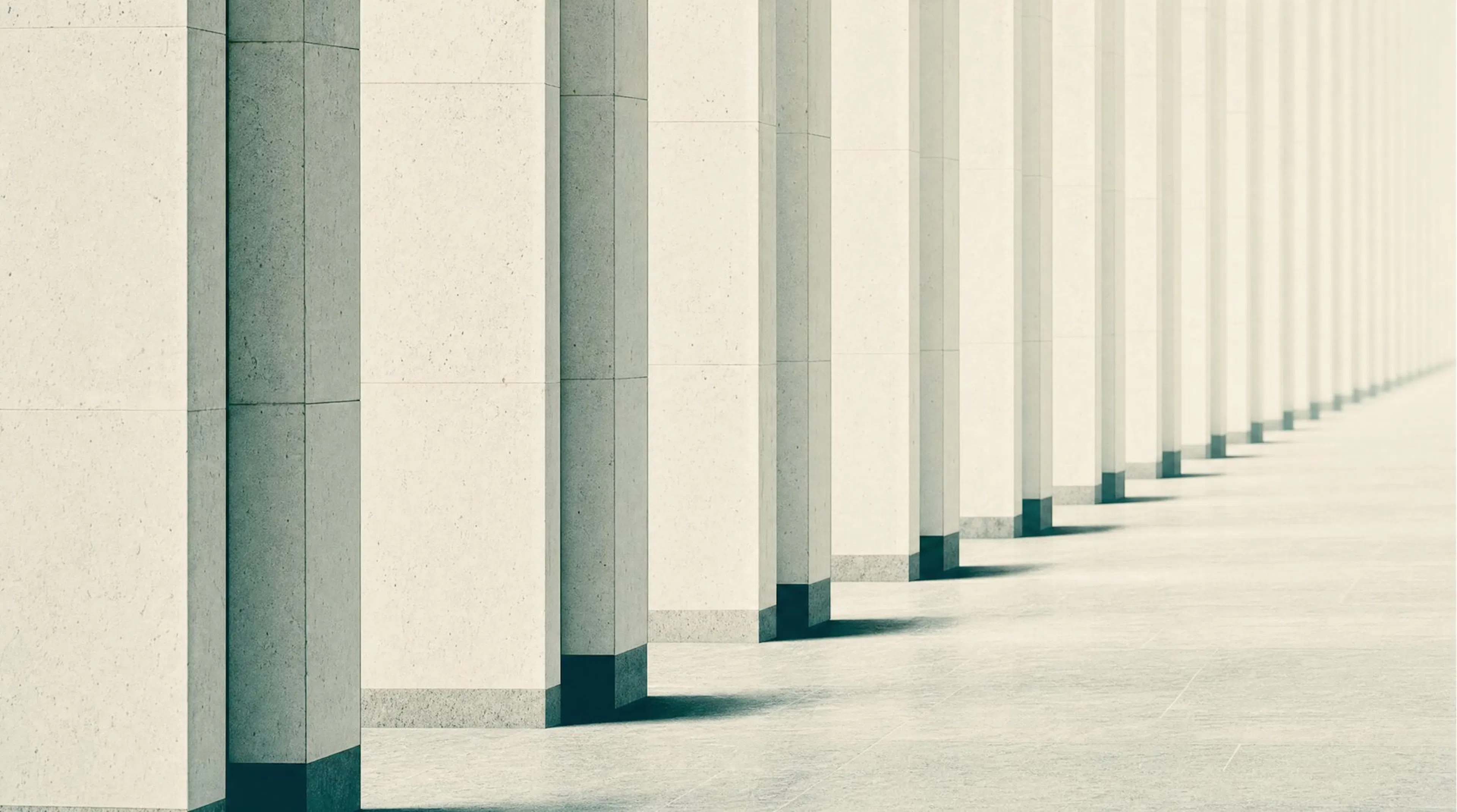 A colonnade of identical limestone pillars receding into mist