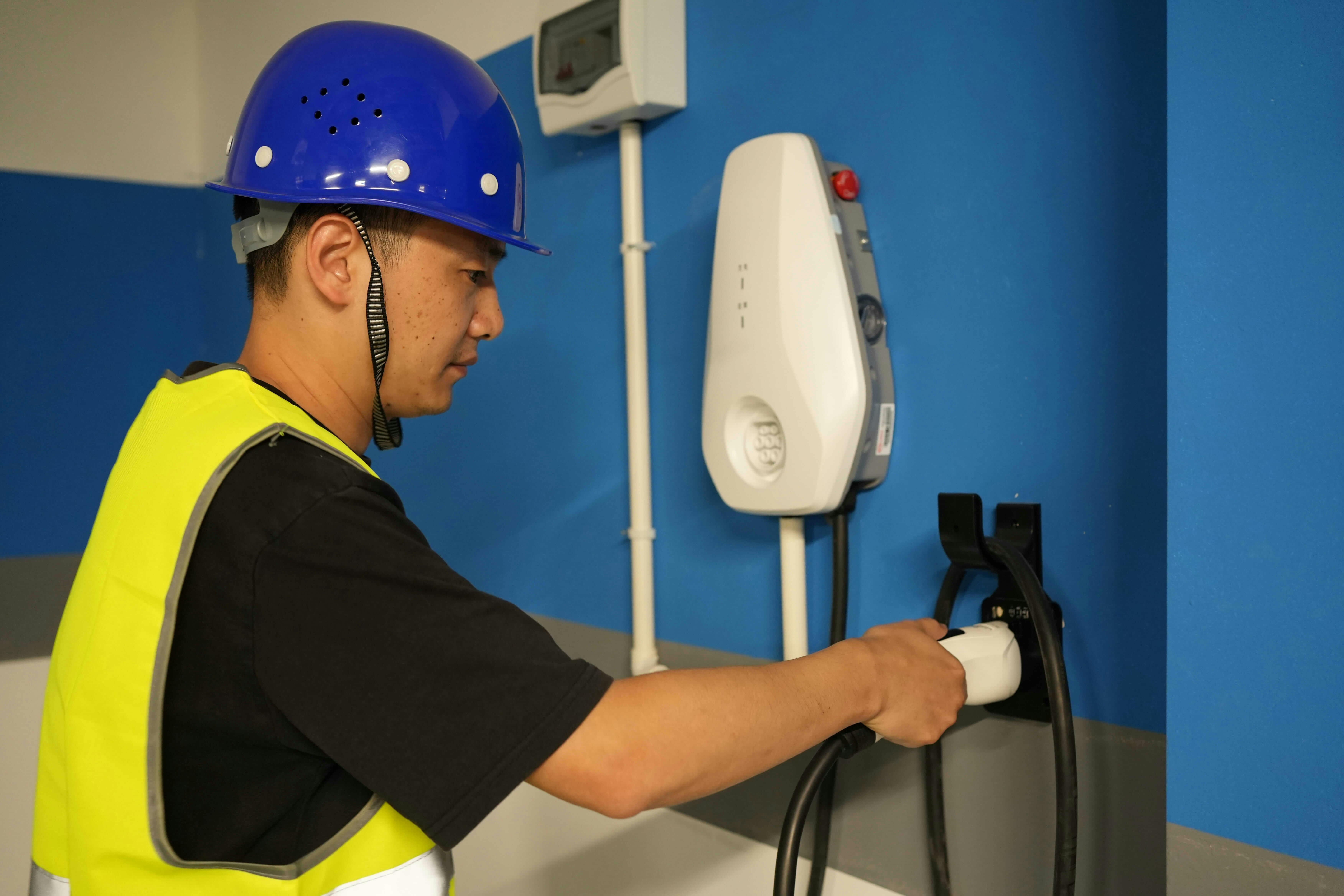 Electric vehicle charger installation: Technician connecting charger to homeowner's power supply