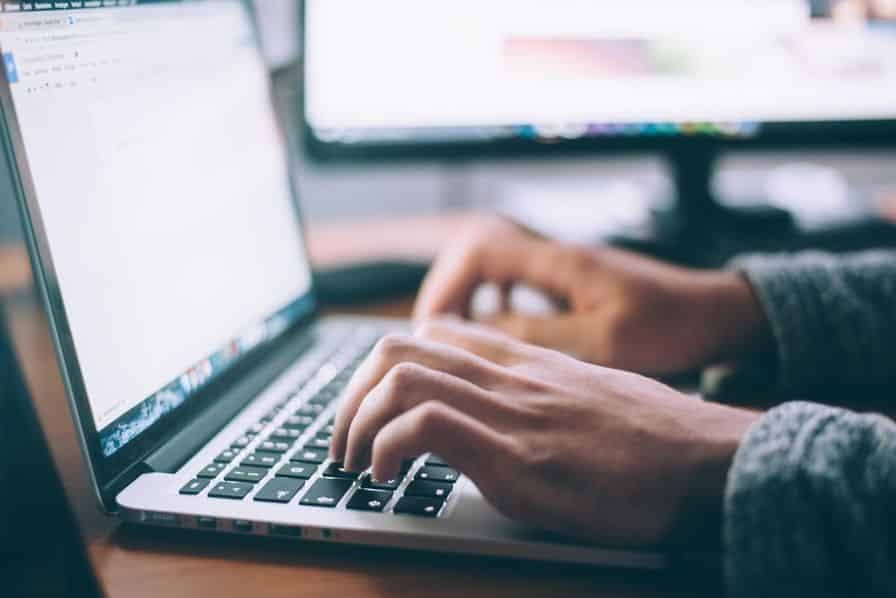 A person typing on a computer the meaning of image identification