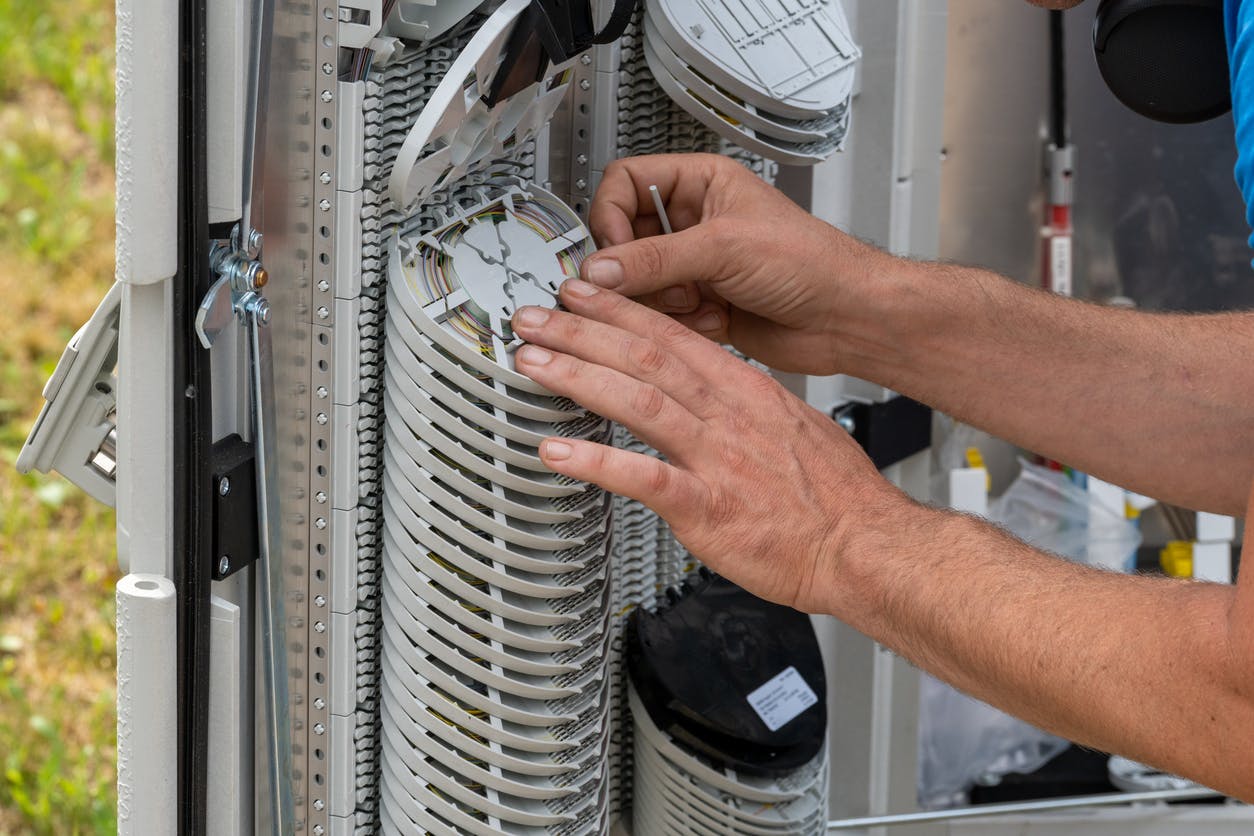 Technicien travaillant sur les cassettes d'un point de distribution fibre