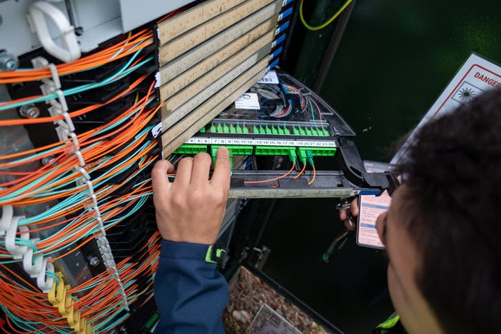 Technicien opérant de la maintenance sur une armoire de fibre optique