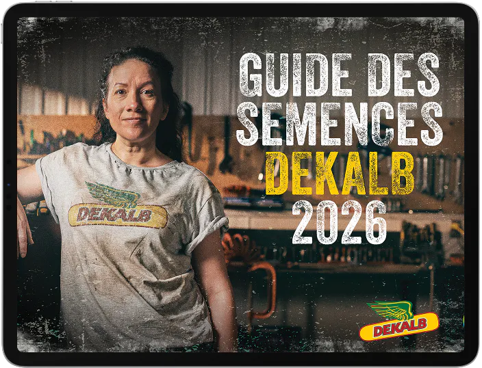 Une femme portant un t-shirt DEKALB se tient devant un atelier. Le texte indique « Guide des semences DEKALB 2026 » et les logos DEKALB et Bayer sont affichés en bas à droite. 