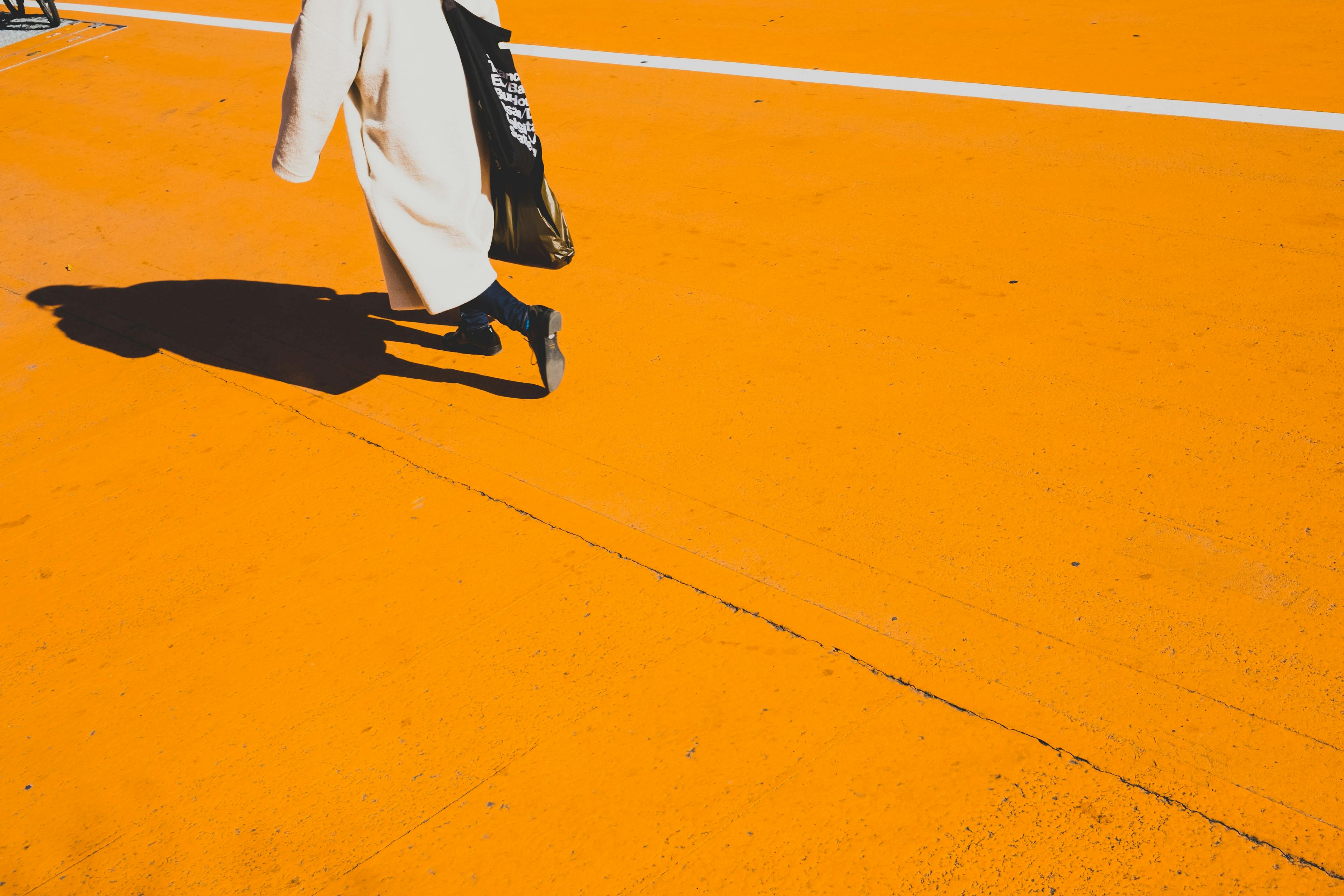 En person korsar en bred orange gata