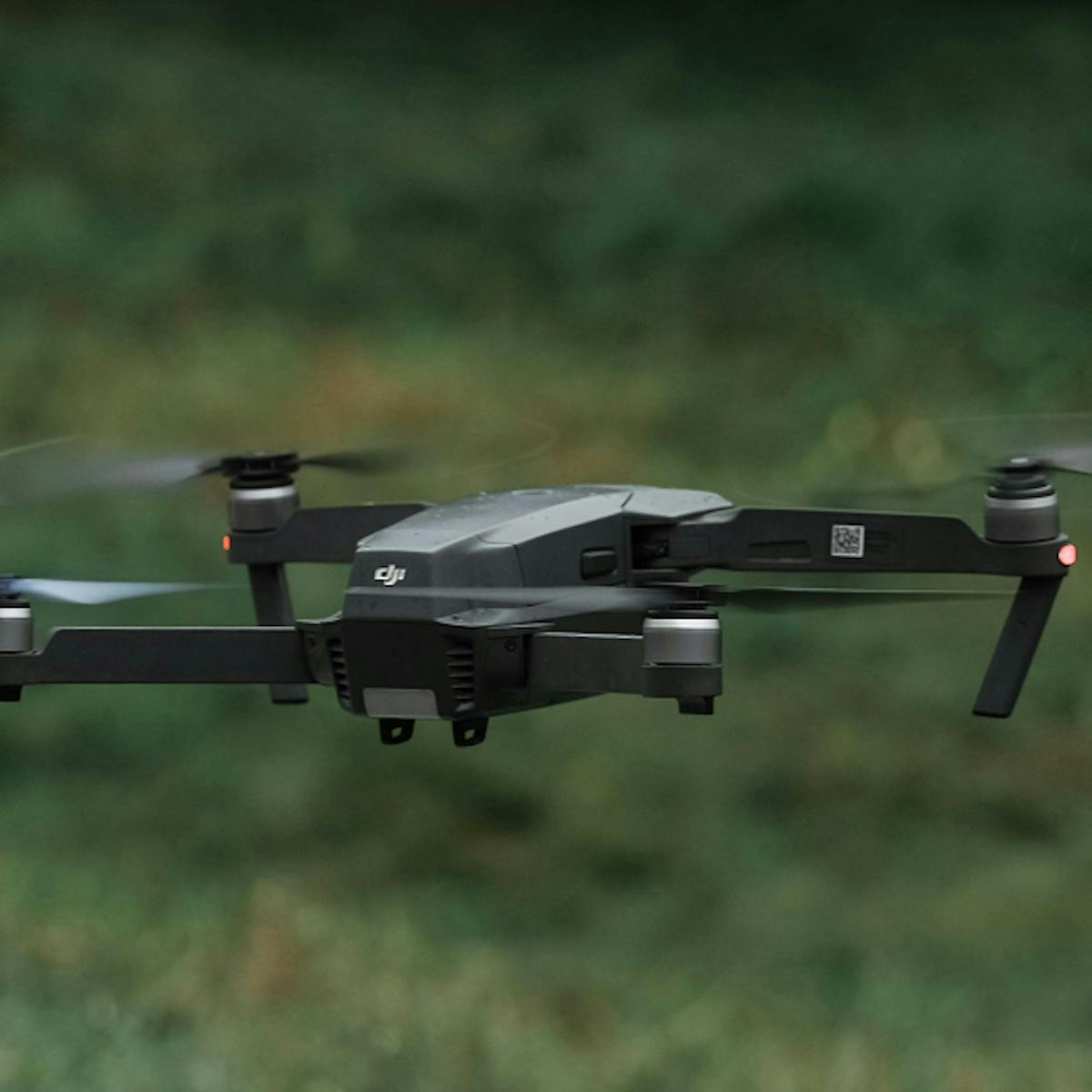 Drone flying over green landscape.