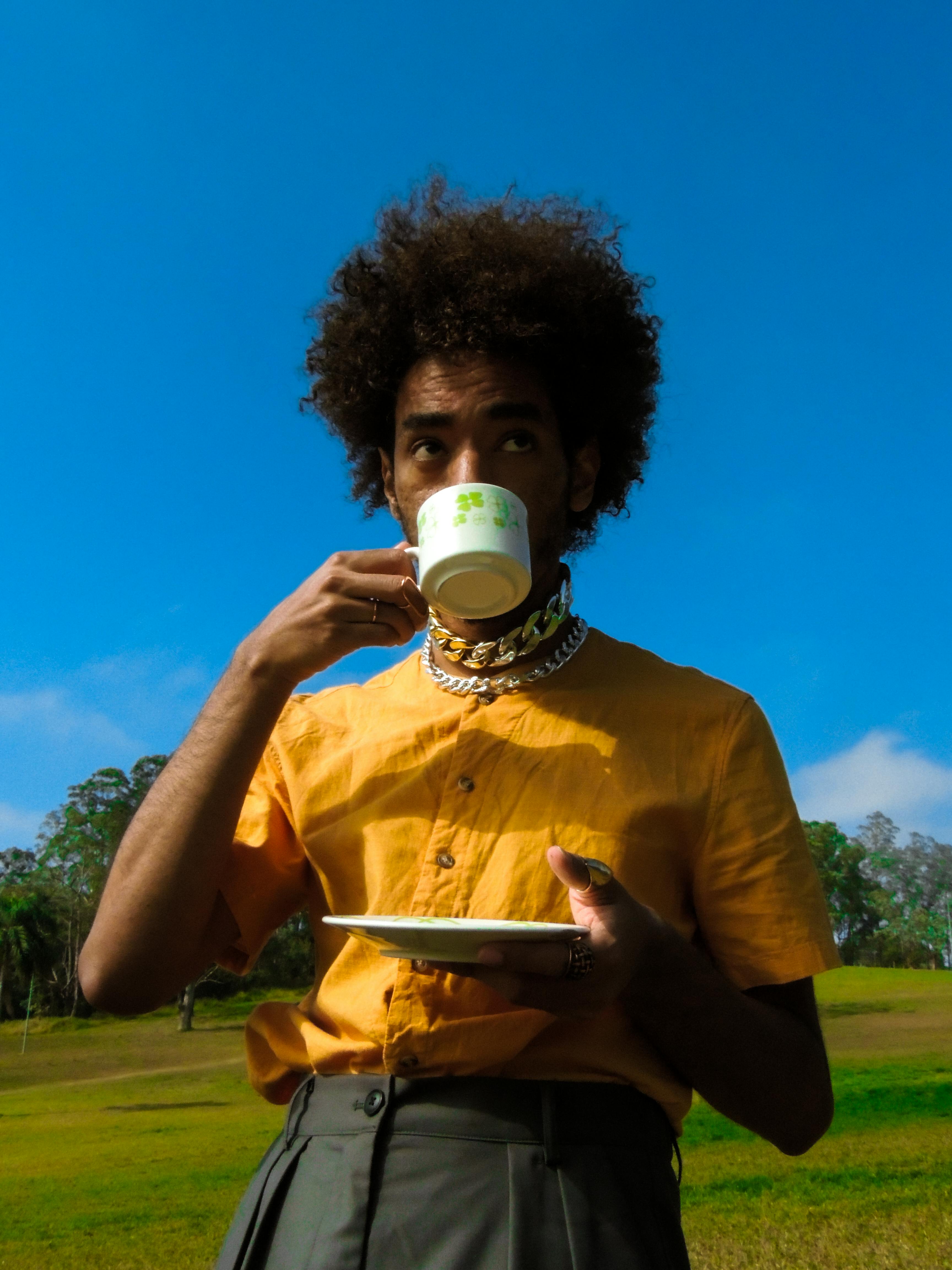 menino thito em pé numa clareira tomando chá