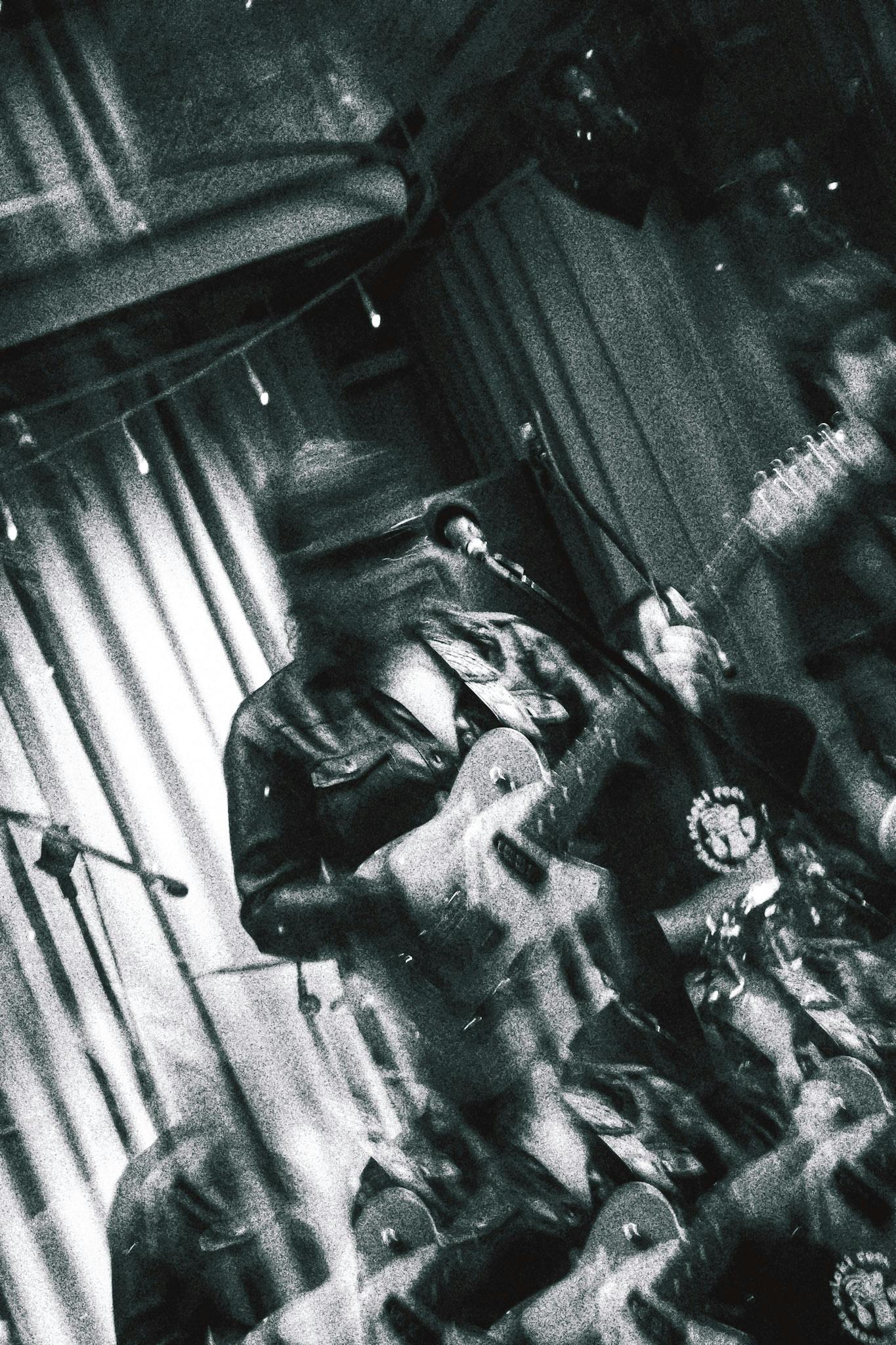 Madre tocando sua guitarra em uma imagem em preto e branco