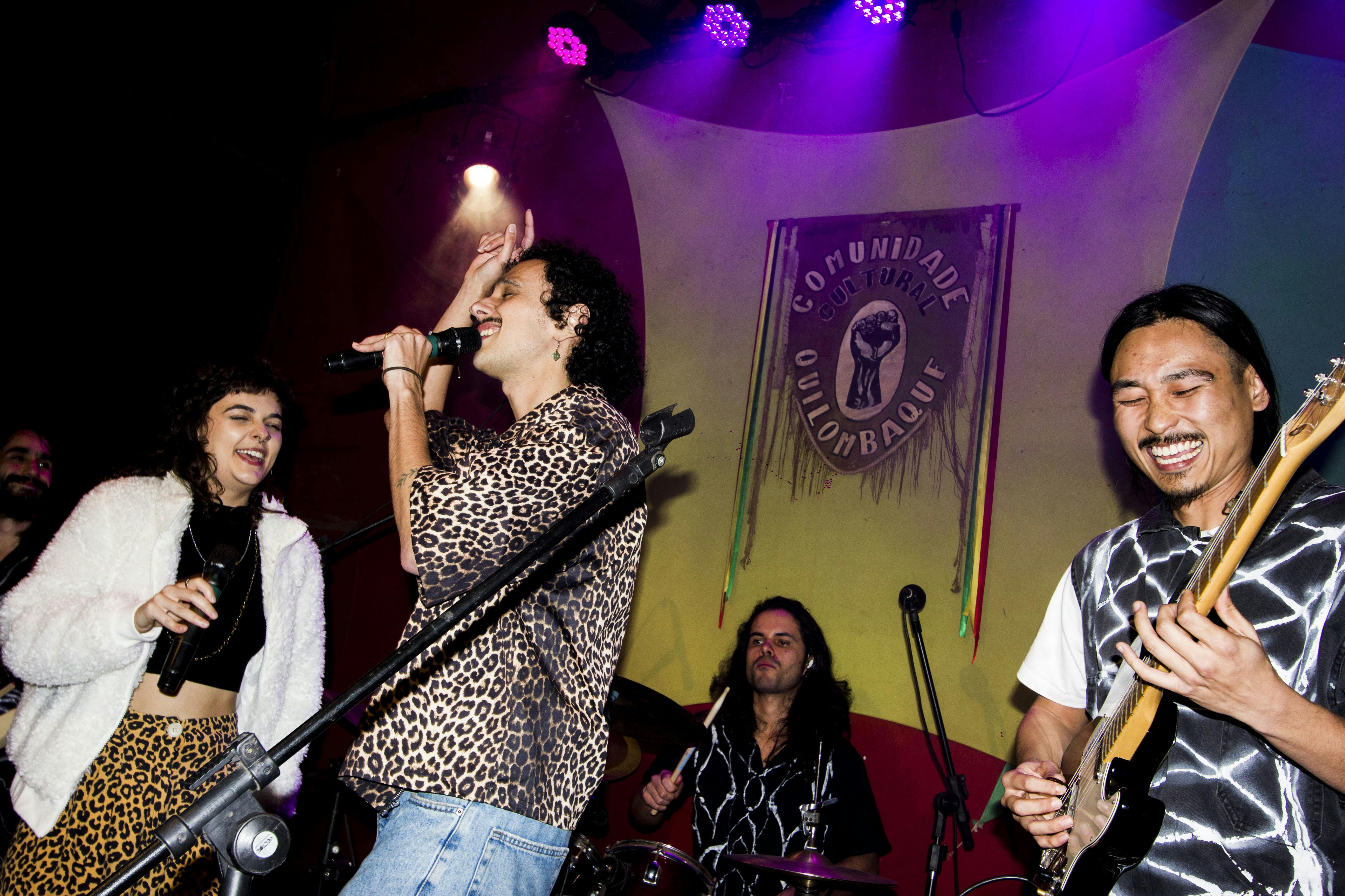 Guitarrista ri enquanto vocalistas animam a platéia