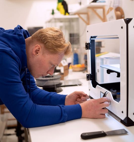Image of a man working with a 3D printer