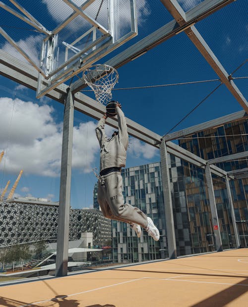 Image of a man slam dunking a basketball on a rooftop basketball court