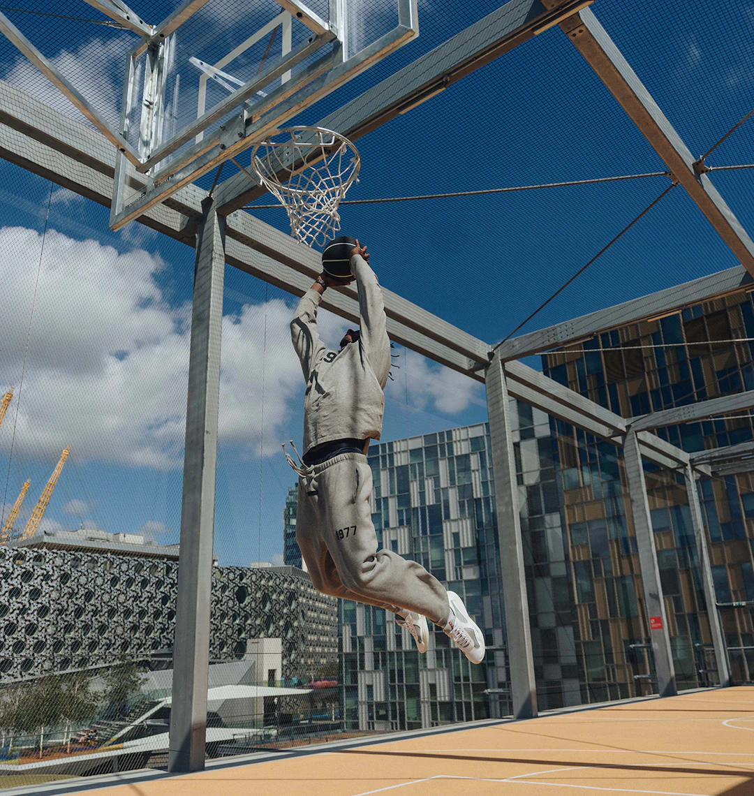 Image of a man slam dunking a basketball on a rooftop court