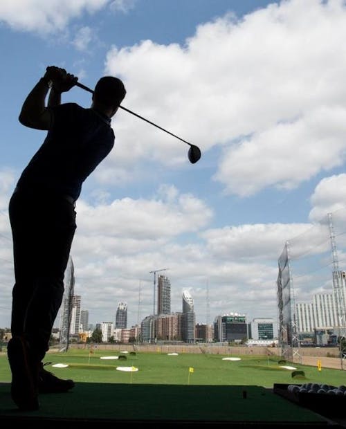 Image of a man playing golf on a driving range