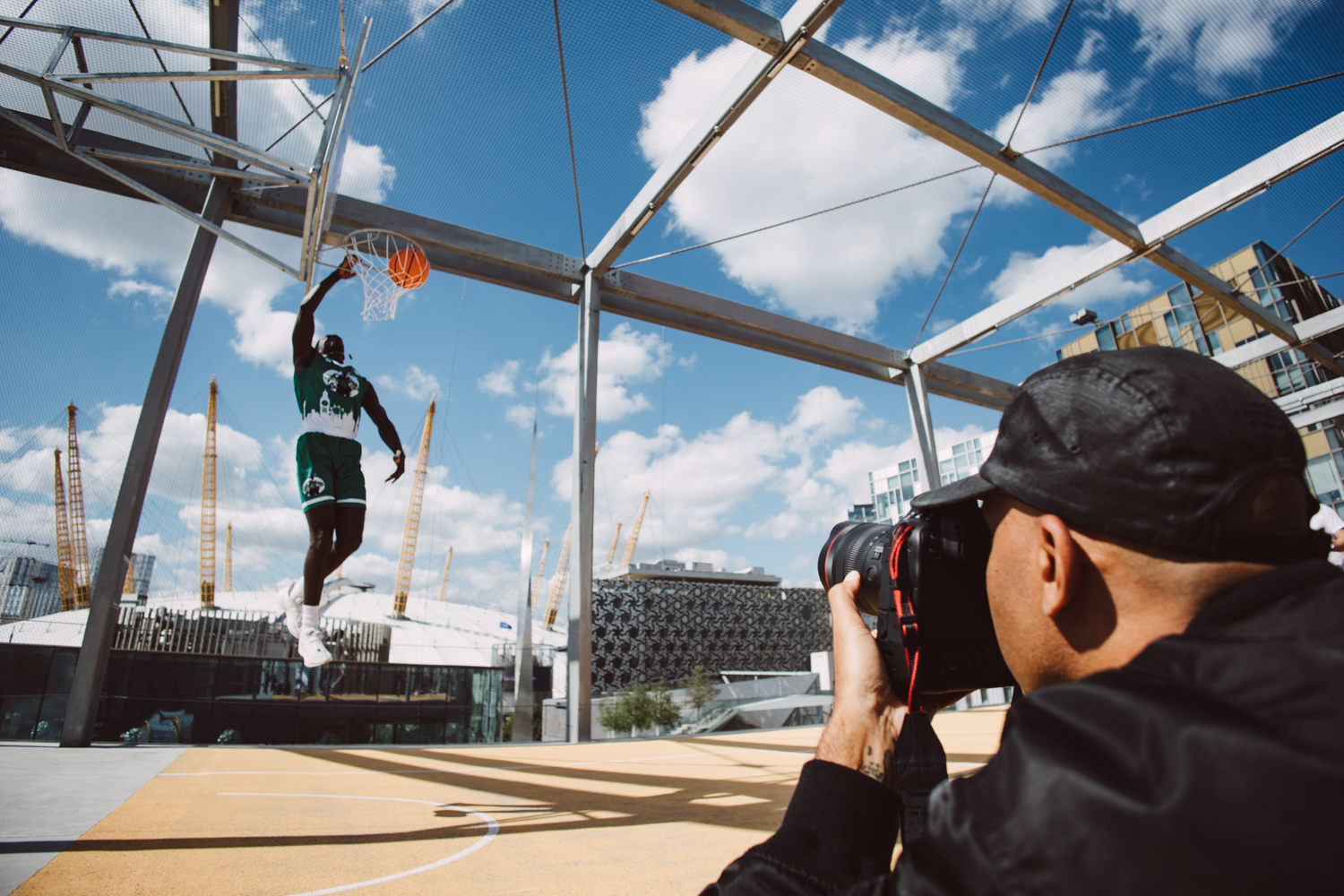 Person playing basketball at a rooftop basketball court in London