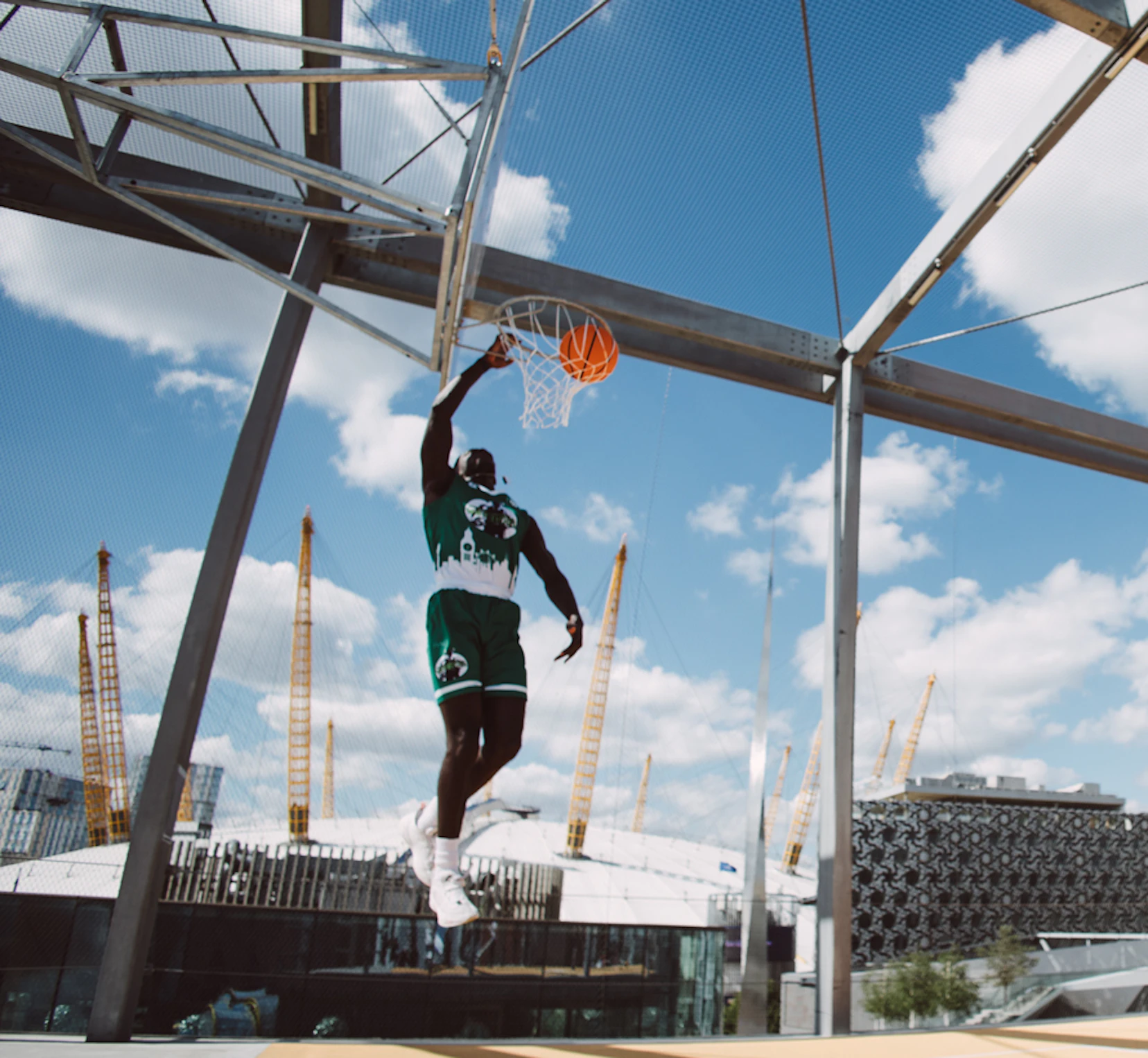 Person playing basketball at a rooftop basketball court in London