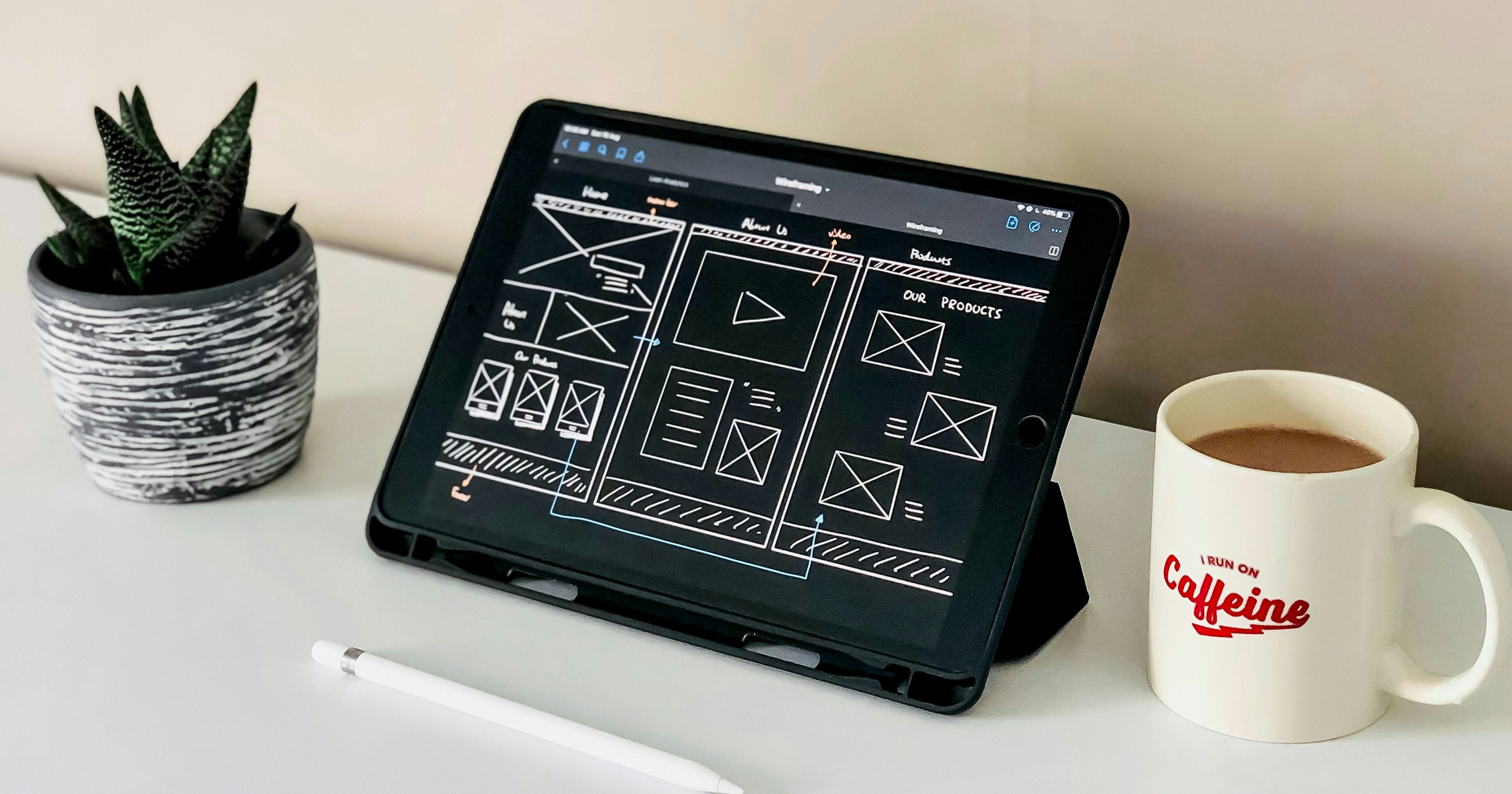 Website schematics showing UI & UX design on a tablet