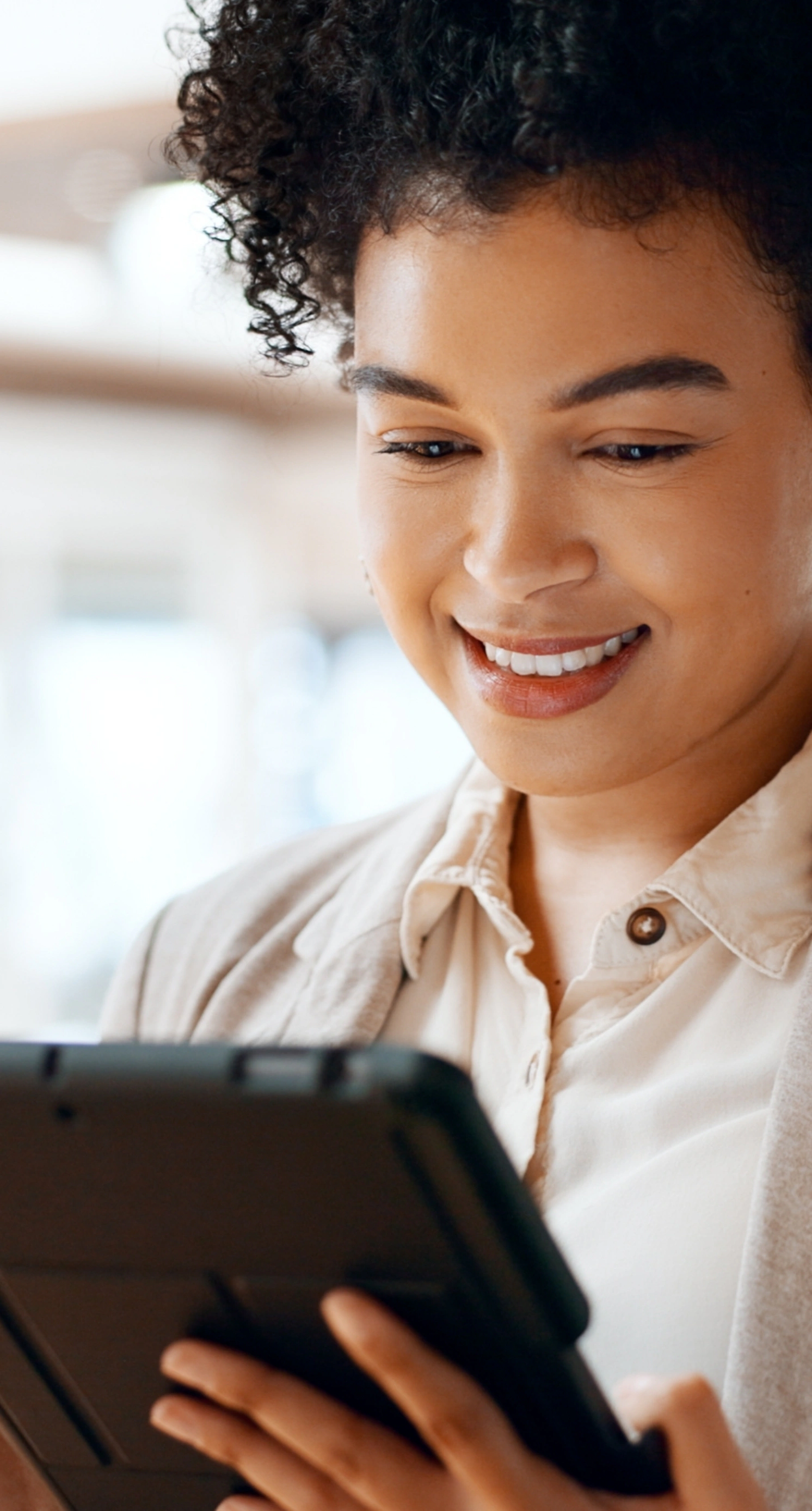 A female smiling and looking at a tablet