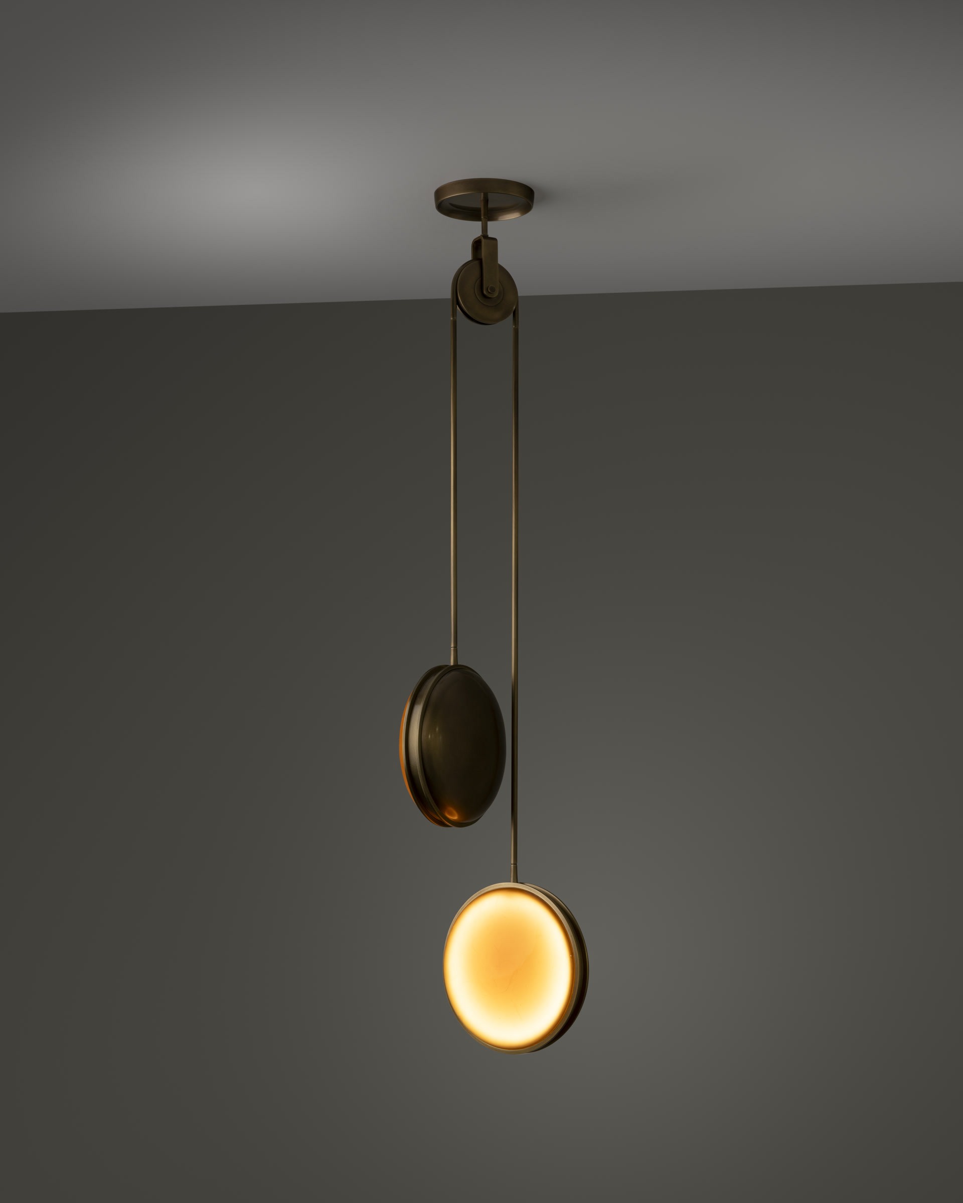 de sousa hughes monos pulley pendant antique bronze amber polished lens dark background