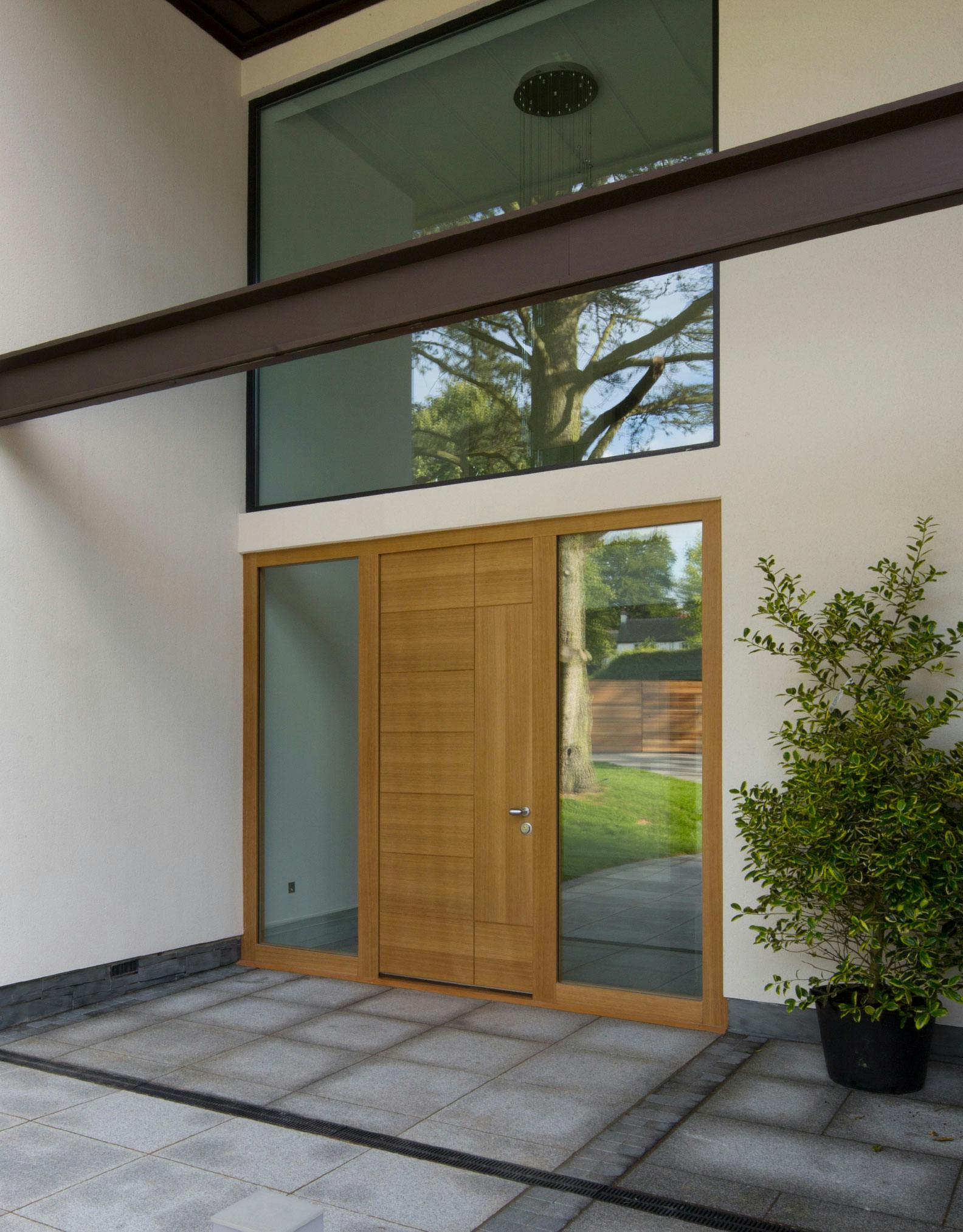 A grand entrance of ultra-contemporary home featuring made-to-measure front door by Deuren - Versare style in a natural oak finish. with two glazed side lights.