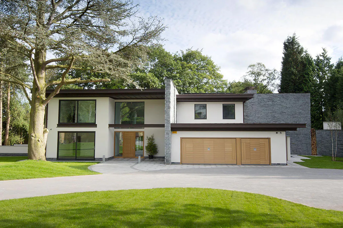Ultra-contemporary home exterior with large expanses of glass and featuring matching front and garage doors by Deuren - Versare style in a natural oak finish.