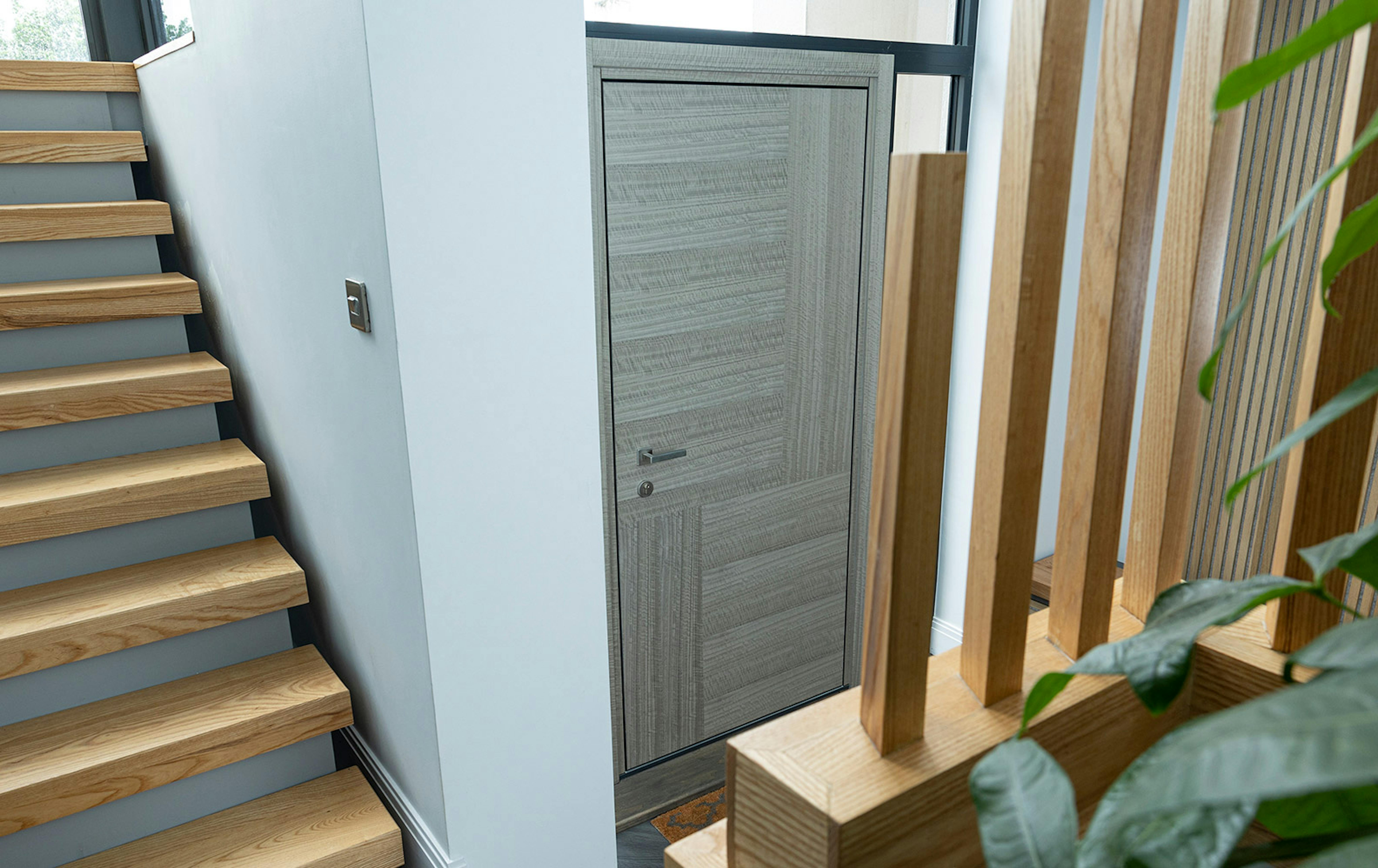 A contemporary internal door by Deuren - Vario 4 style, Eucalyptus (grey grain) finish with chrome lever handle. Set in a contemporary hallway