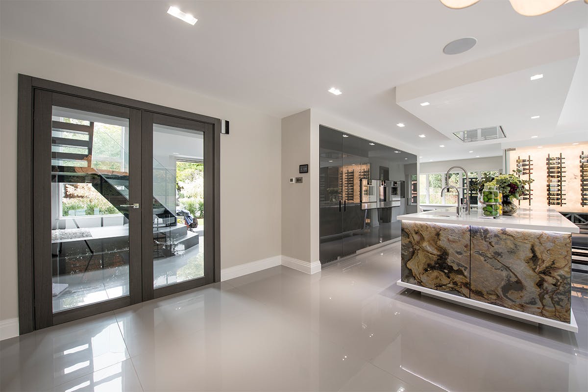 Luxury open plan kitchen/dining area with pre-hung double glazed Gio door design by Deuren, all finished in Grey Oak to harmonise with the grey interior.