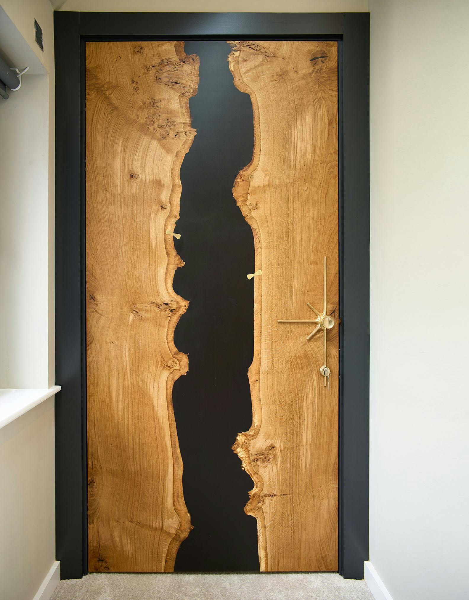 Bespoke Deuren door design using pippy oak as the main material and a central vertical strip of dark resin.