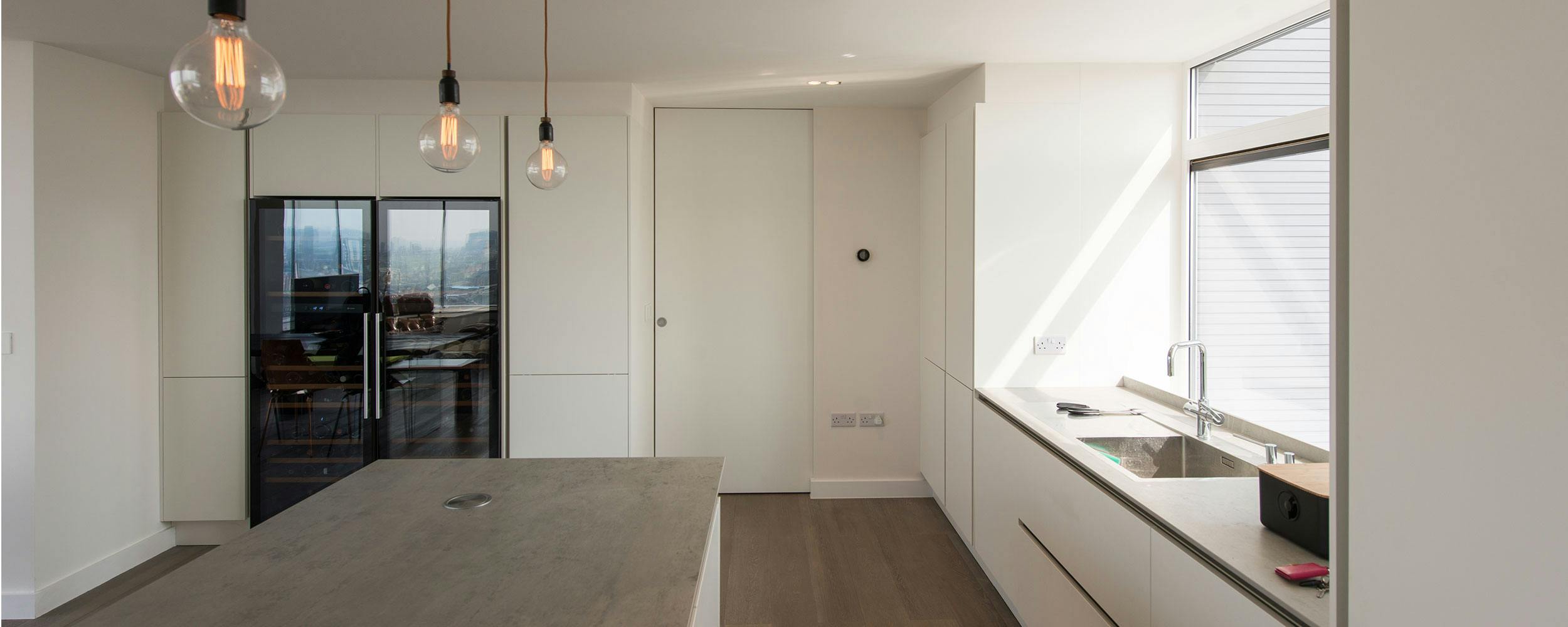 A modern kitchen with a white sliding internal door.