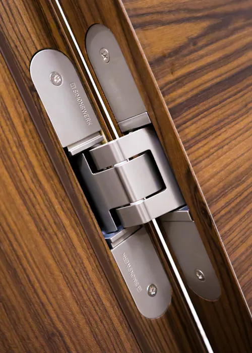 Stainless steel door hinge on a wooden door.