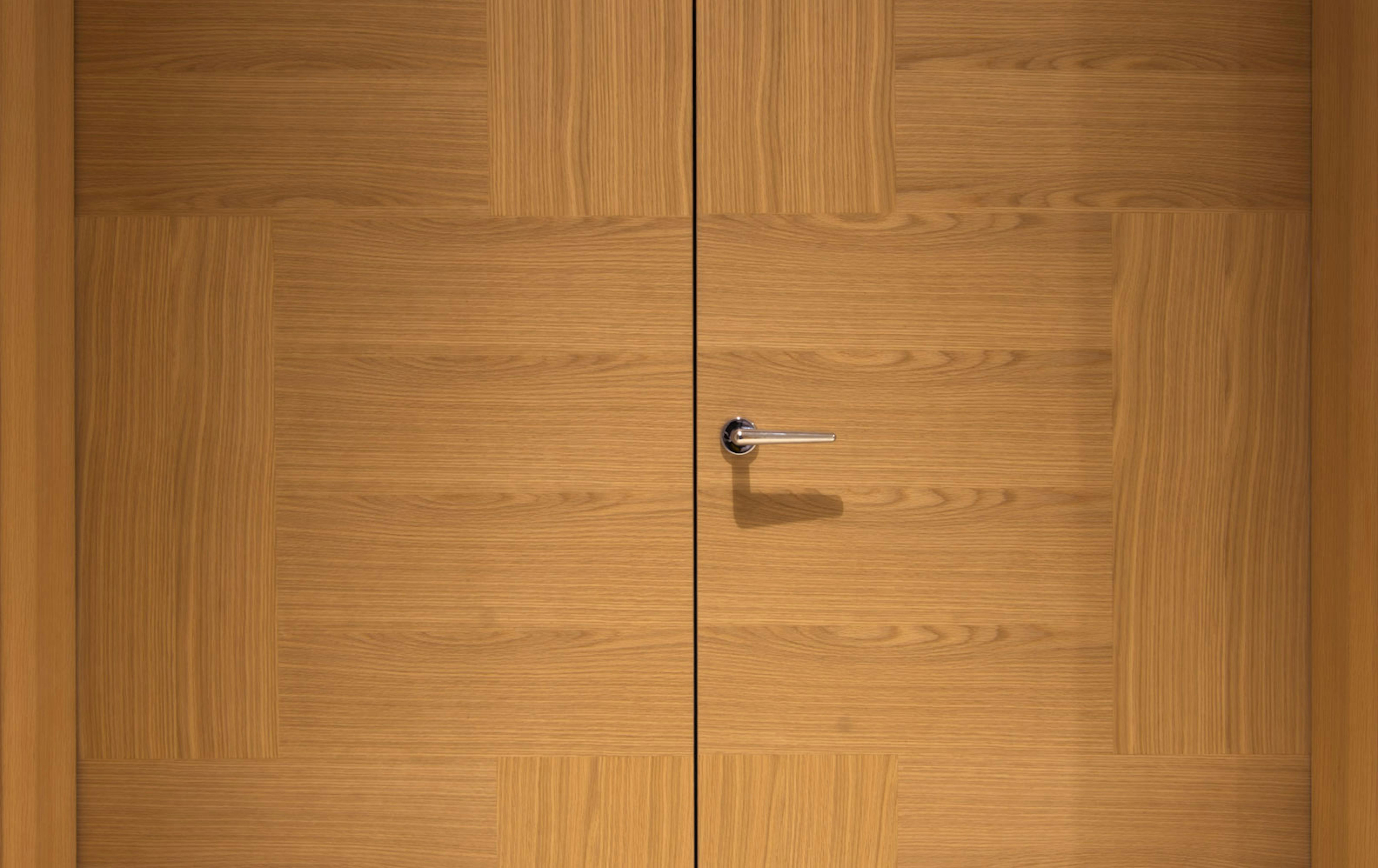 A close up of Deuren double leaf, pre-hung door set - Vario 6 style in natural oak and chrome lever handle