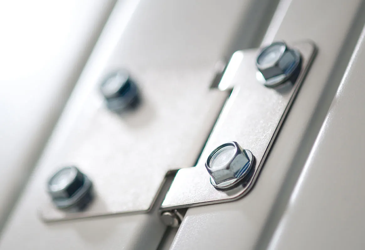 Close-up of a metal door hinge with two silver screws.