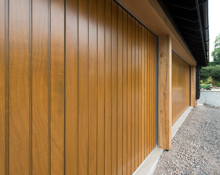 Close-up of a brown wooden garage door with a vertical wood grain.