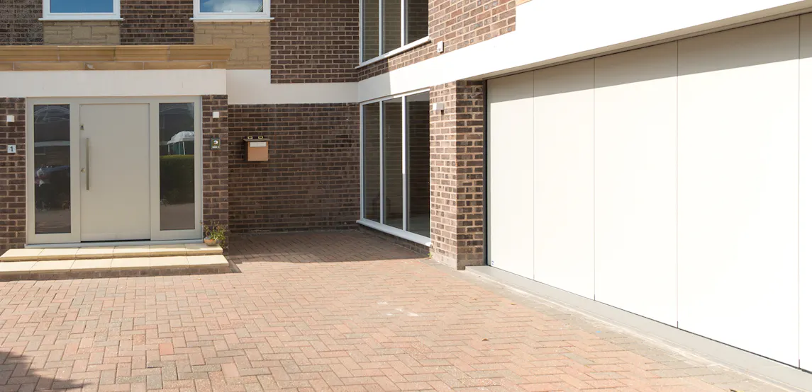 A modern house with matching white front and garage doors