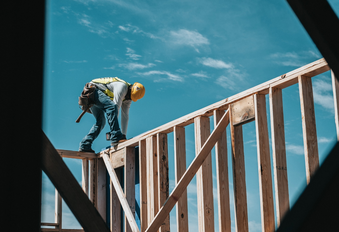 A construction worker on the frame of a house