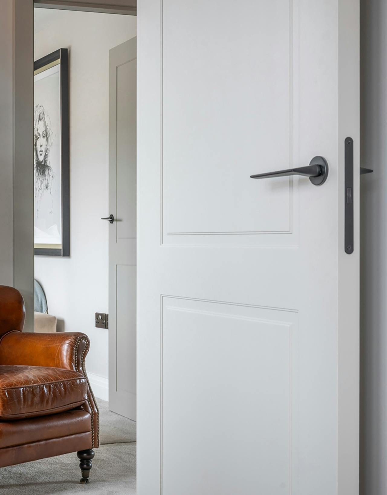 View of a spacious landing through an open Deuren door set, in a classic Victorian style and finished in a light grey paint.